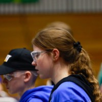 A student watches her robot during the competition